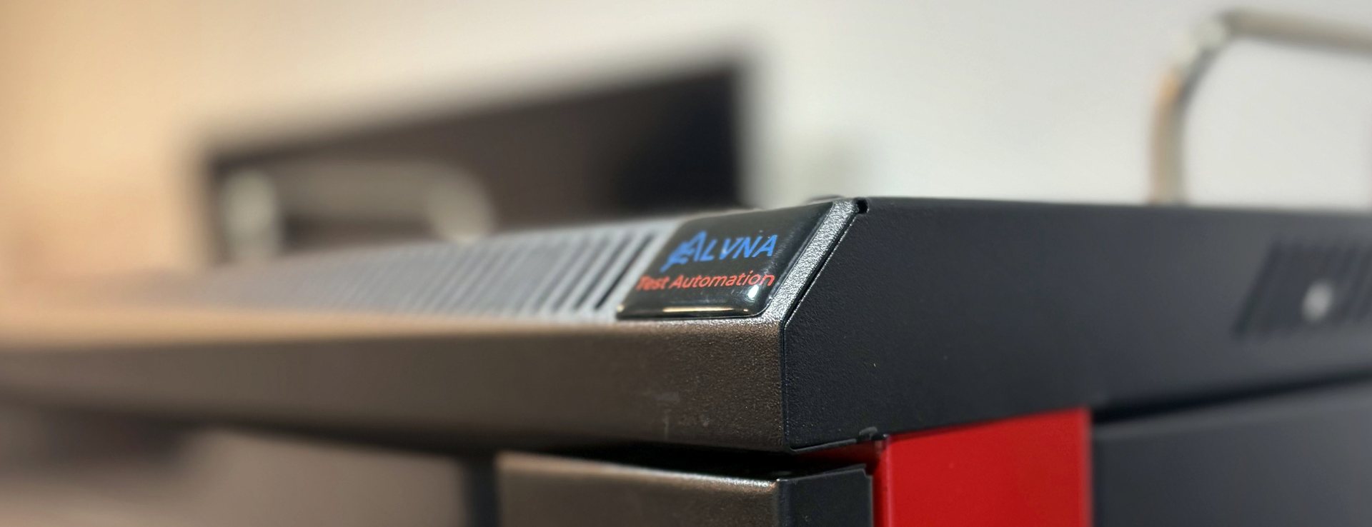 Close-up of the ALVNA badge on a test unit roof panel, with red trim visible